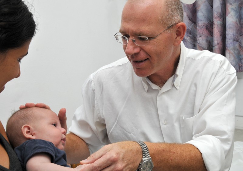 ד"ר דוד לשם בודק פעוט במסגרת השירות לכירורגיה פלסטית בילדים